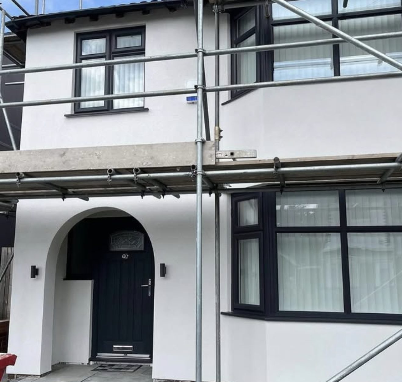Semi-detached house in new white render with scaffolding still up